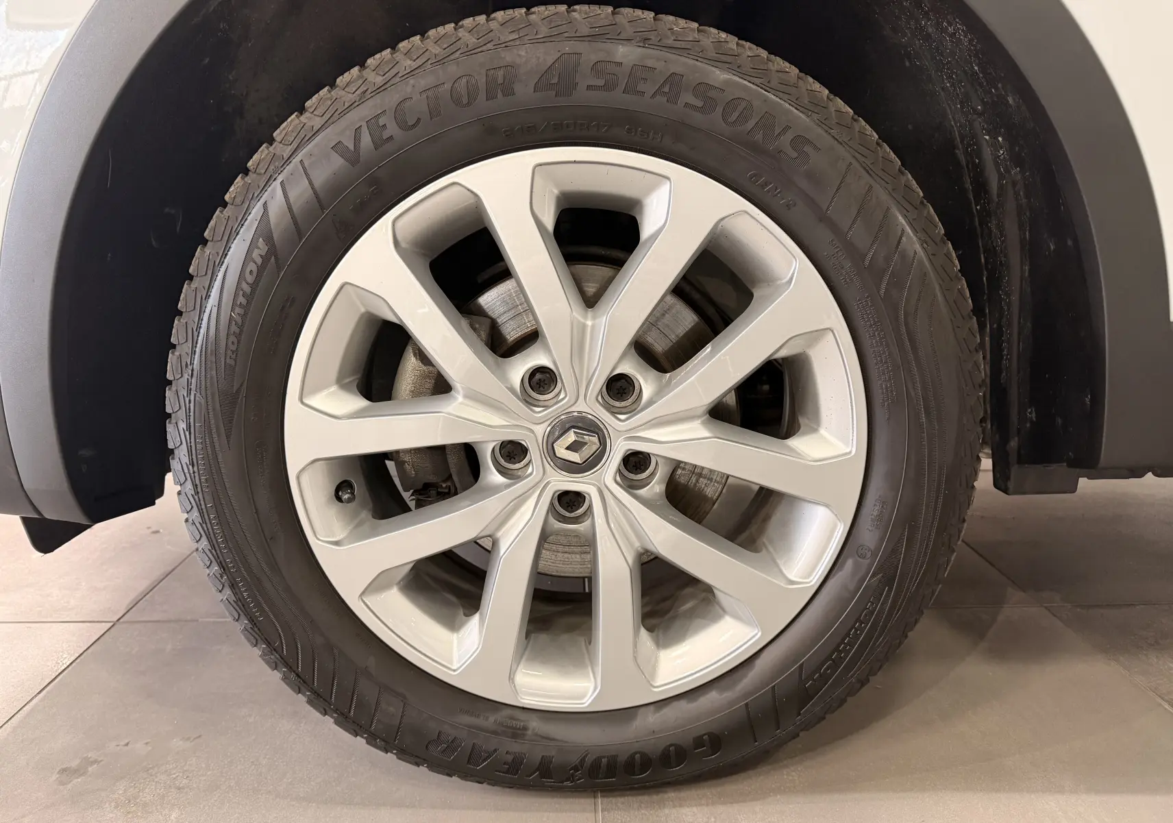 Gros plan sur la roue avant droite du Renault Kadjar blanc Glacier, jante alliage 17 pouces avec logo Renault central.