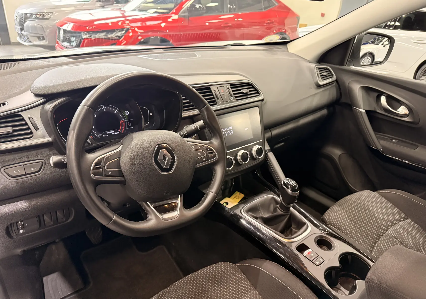 Vue intérieure côté conducteur du Renault Kadjar 1.5 dCi 115 Business 2020, volant multifonctions et boîte manuelle visible.