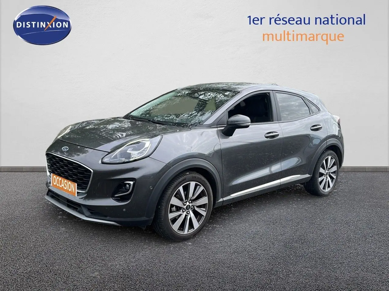 Ford Puma gris 3/4 avant droit, SUV compact avec jantes alliage et calandre noire distinctive.