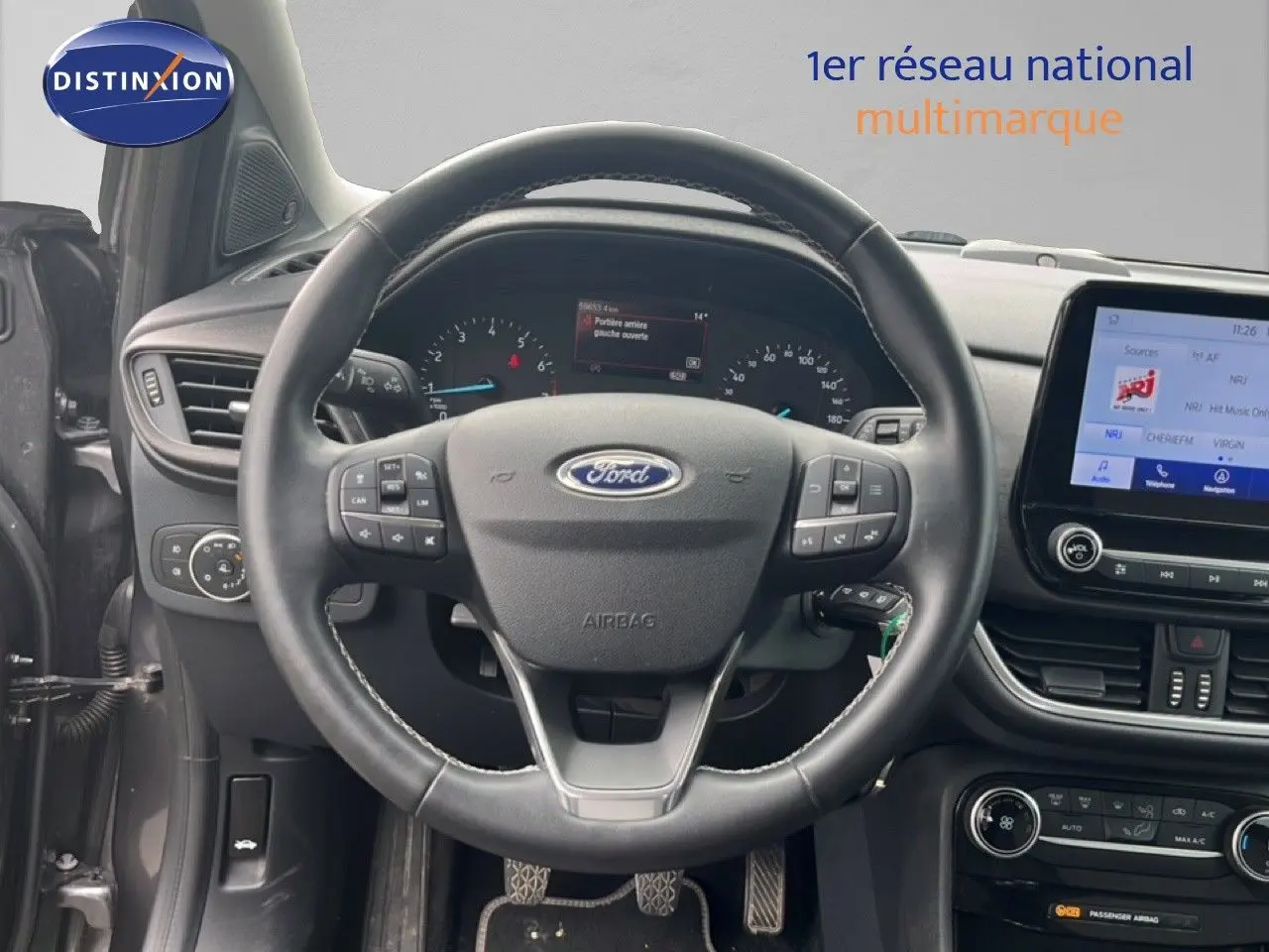 Vue intérieure centrée sur le volant du Ford Puma gris 2021, avec tableau de bord et écran tactile visibles.