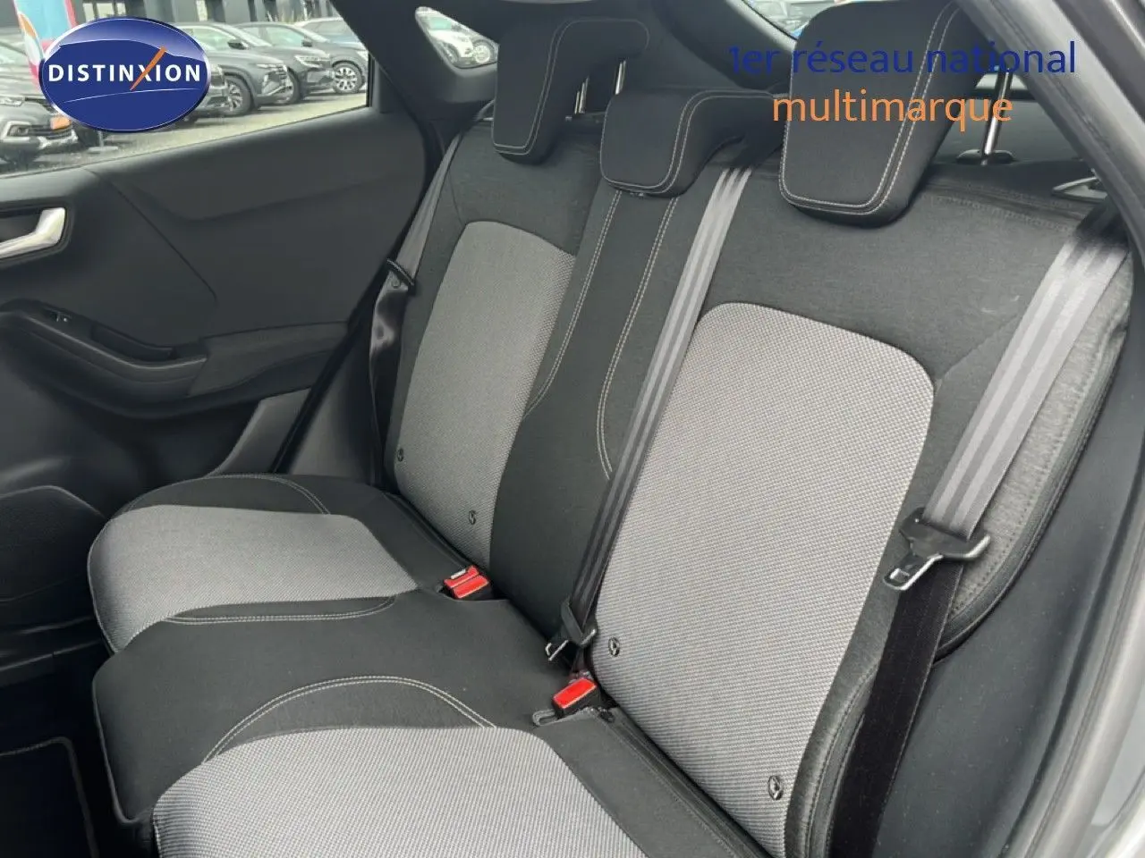 Vue intérieure sur la banquette arrière du Ford Puma gris 2021, avec sièges bi-ton gris et ceintures visibles.