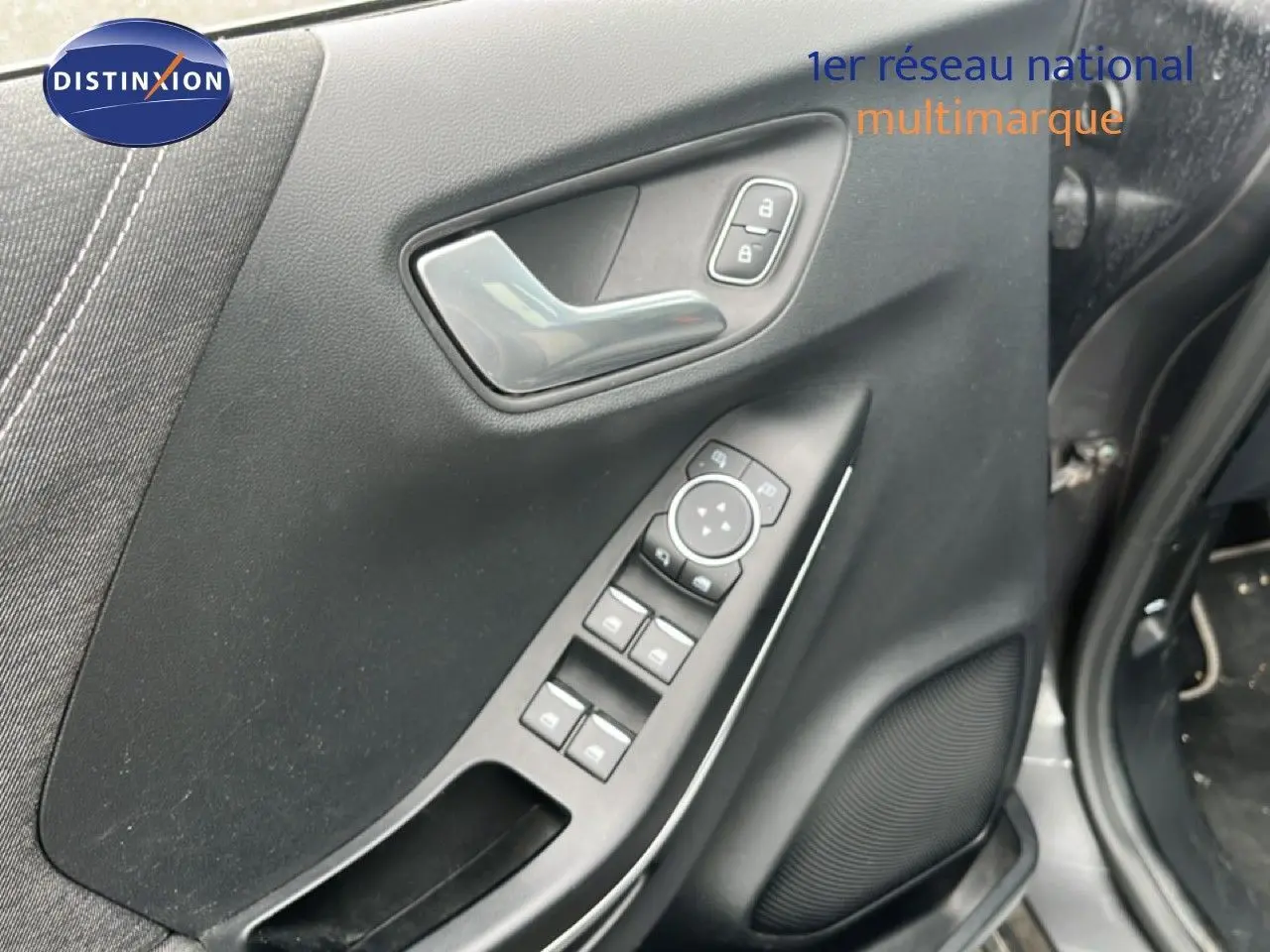 Vue rapprochée de la porte avant gauche grise du Ford Puma 2021 avec commandes électriques et poignée chrome.