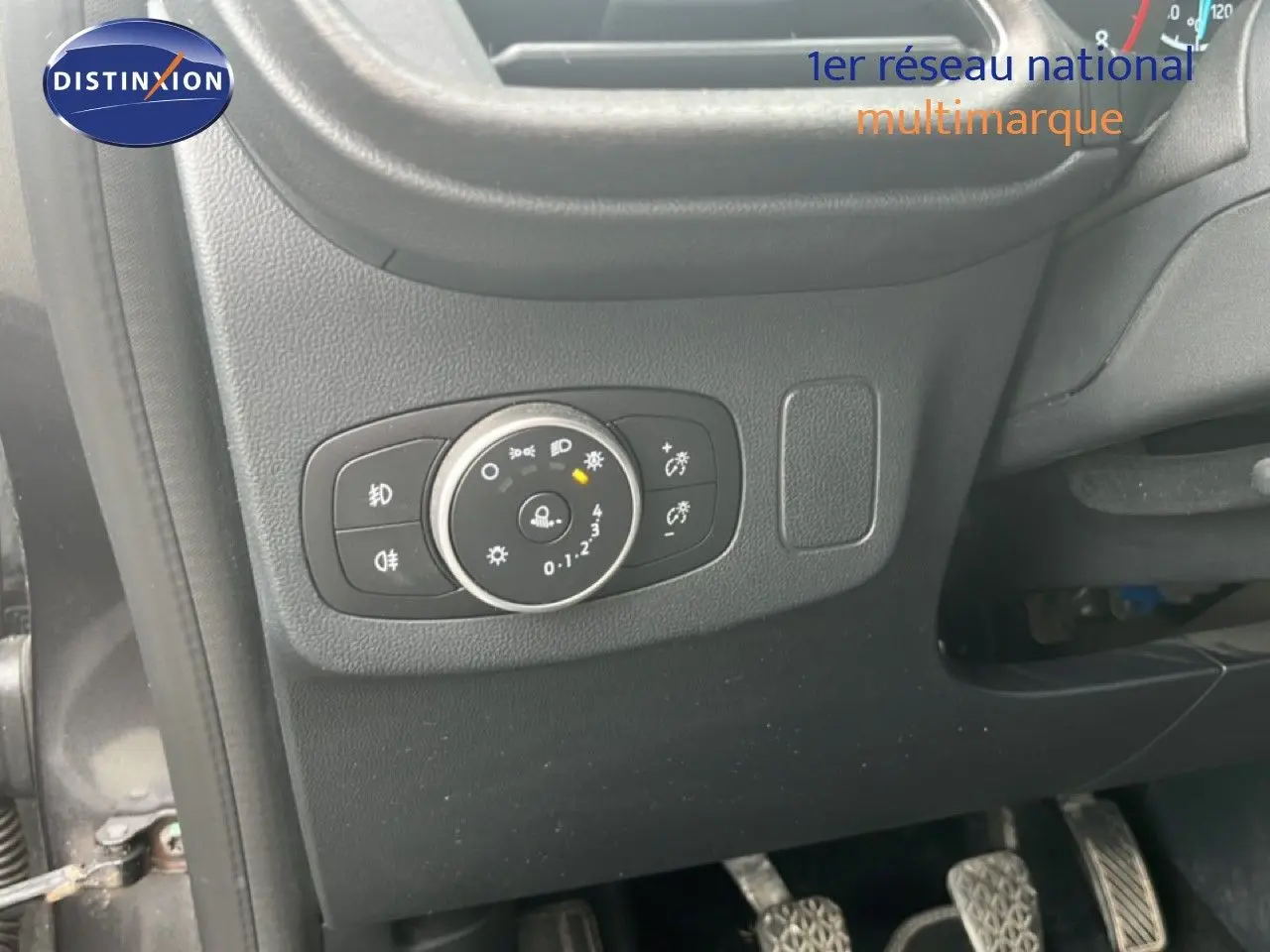Détail du tableau de bord côté gauche du Ford Puma gris 2021, montrant la commande des phares et les pédales.