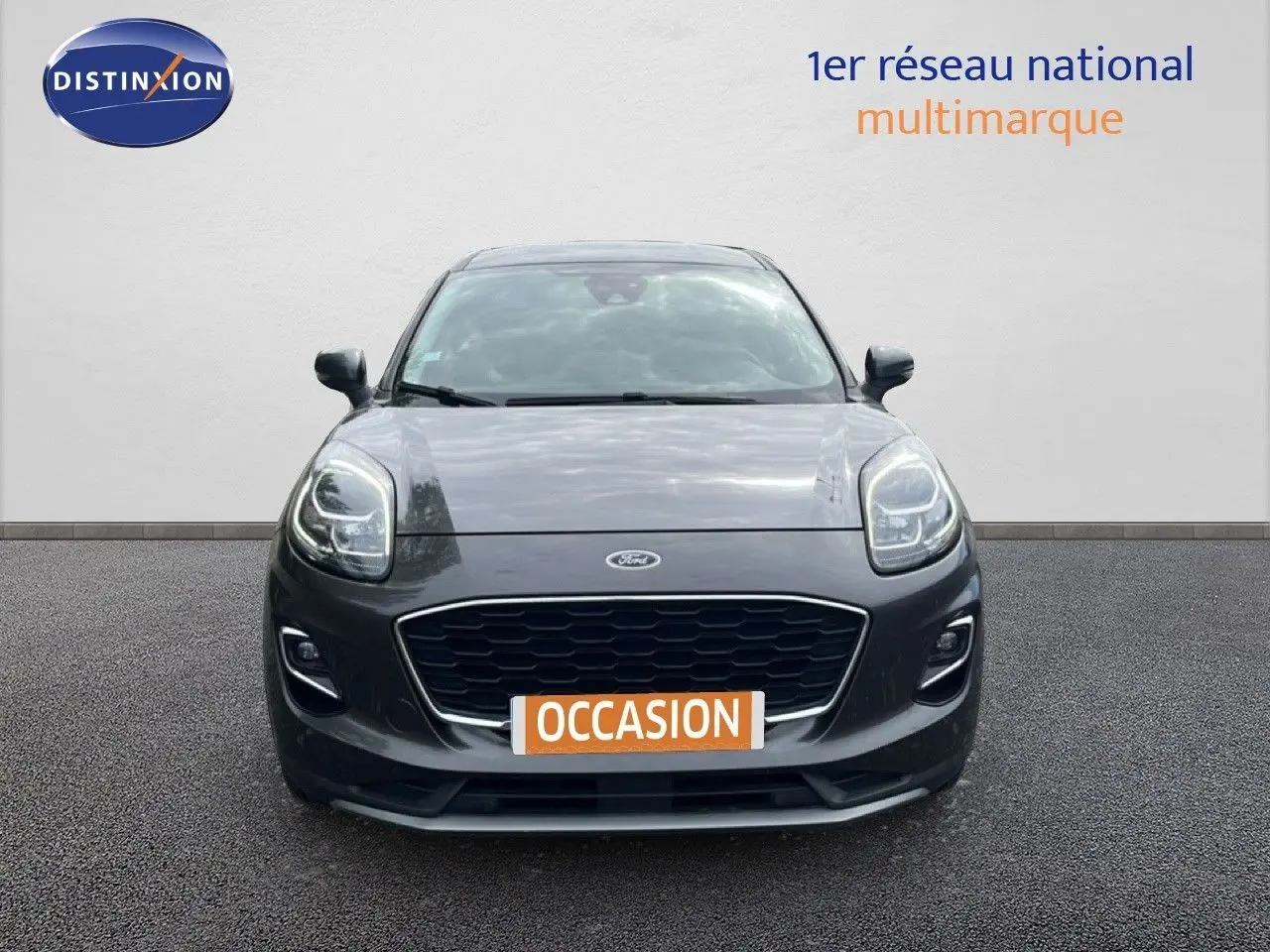 Ford Puma gris 3/4 avant face, version Titanium 1.0 EcoBoost hybride essence, vue frontale centrée.
