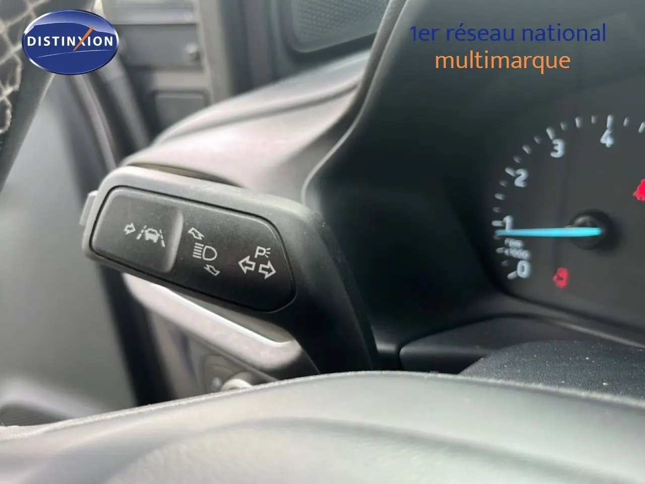 Gros plan sur le commodo gauche du tableau de bord du Ford Puma gris 2021, montrant les commandes d’éclairage et d’aide à la conduite.