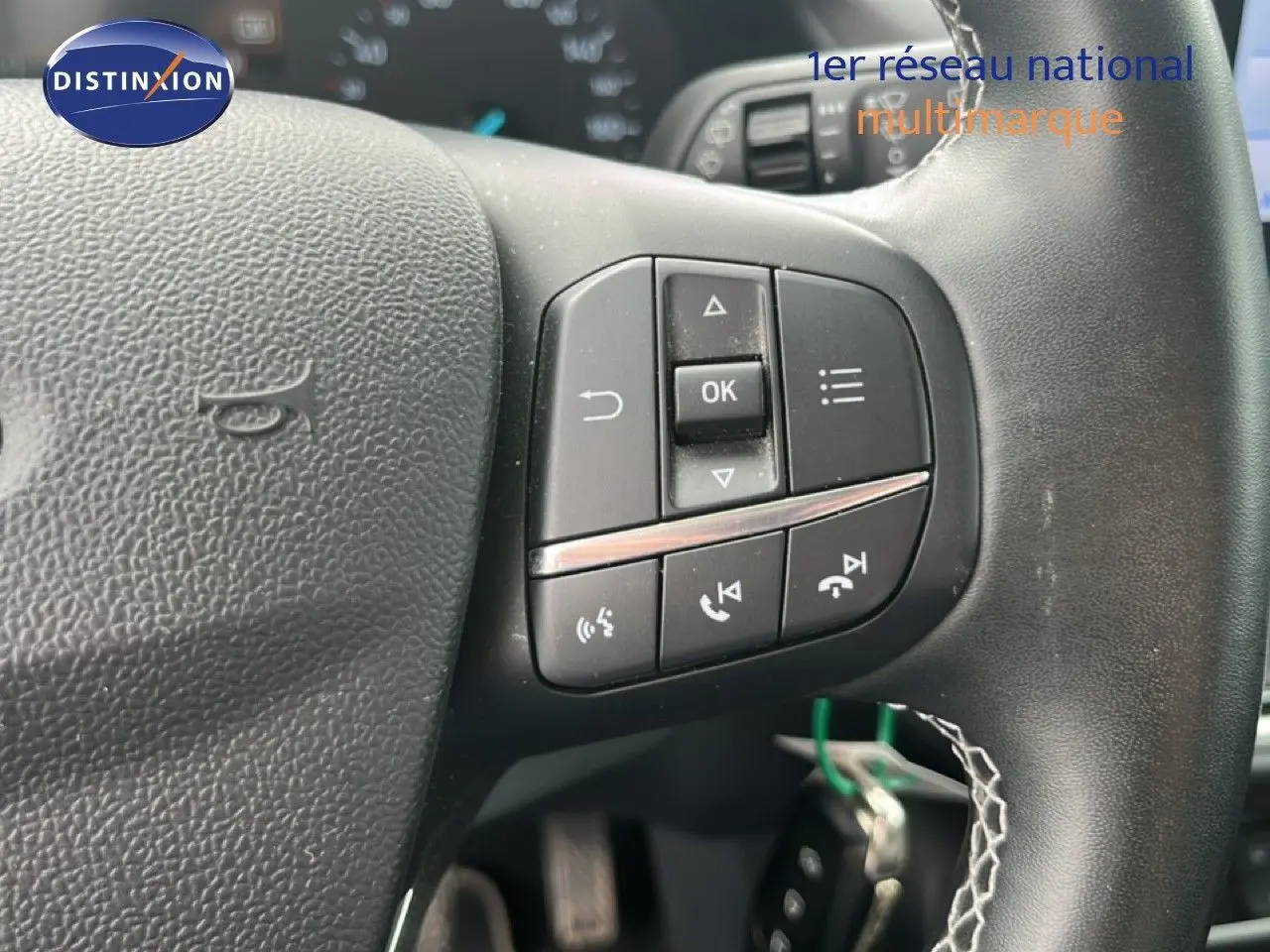 Gros plan sur les commandes multifonctions du volant noir du Ford Puma gris 2021, version 1.0 EcoBoost Titanium.