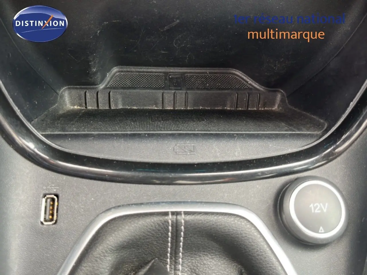 Gros plan sur la console centrale du Ford Puma gris, montrant la prise USB, prise 12V et le rangement devant le levier de vitesse.