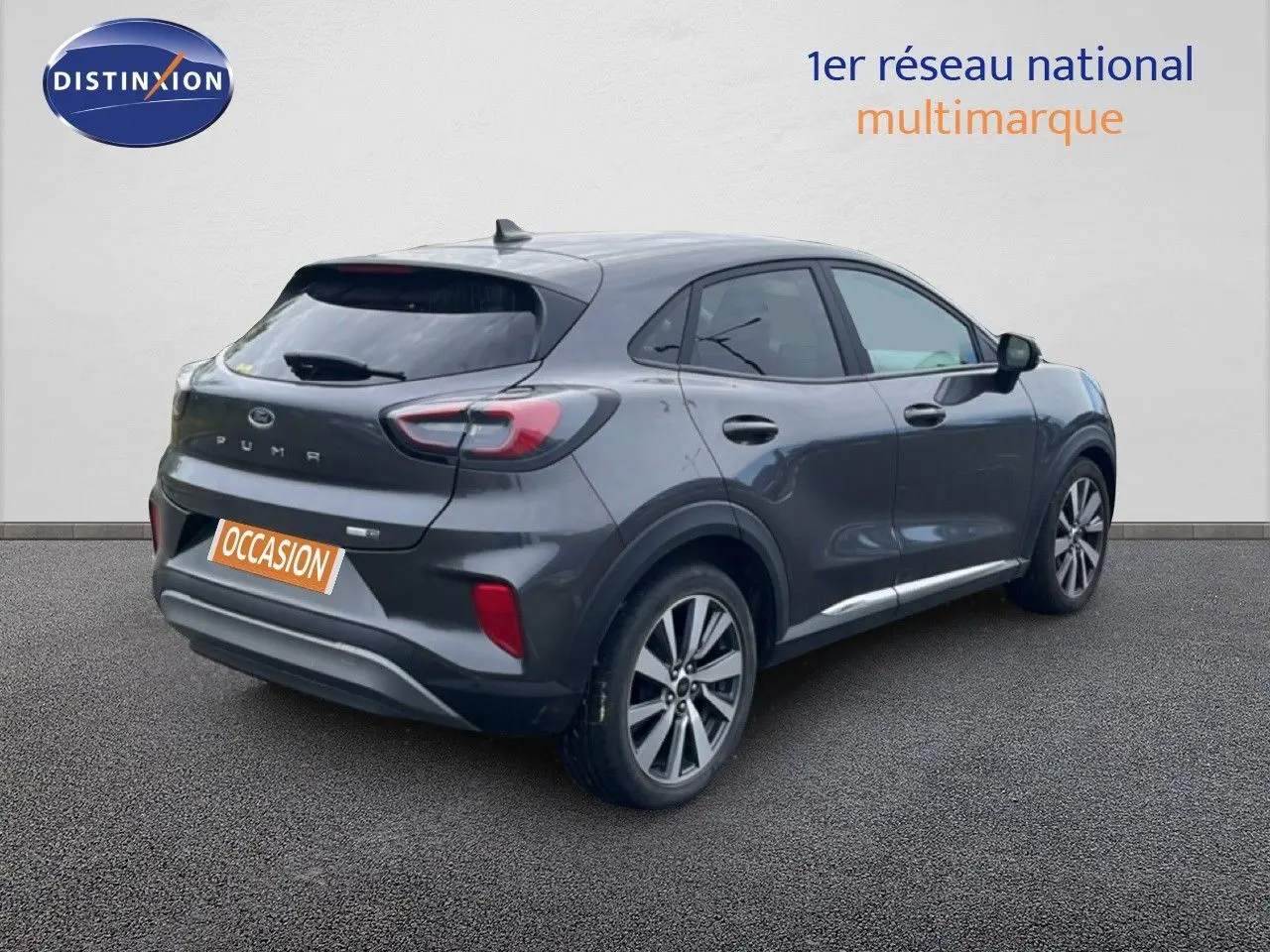 Vue 3/4 arrière droite d’un Ford Puma gris 2021 avec jantes alliage et badge Titanium visible sur le hayon.