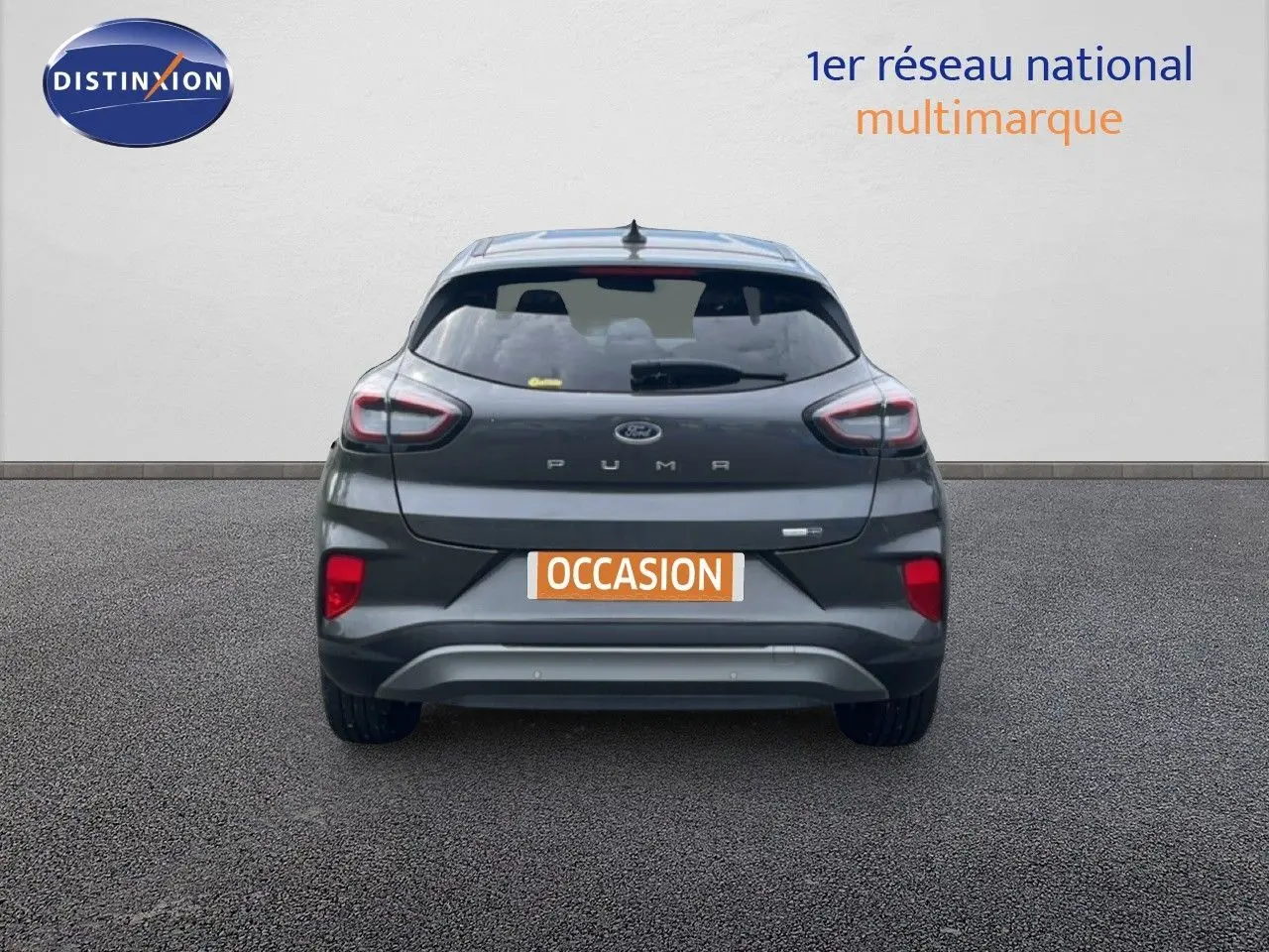 Vue arrière d'un Ford Puma gris 2021 avec feux distinctifs et plaque occasion visible.