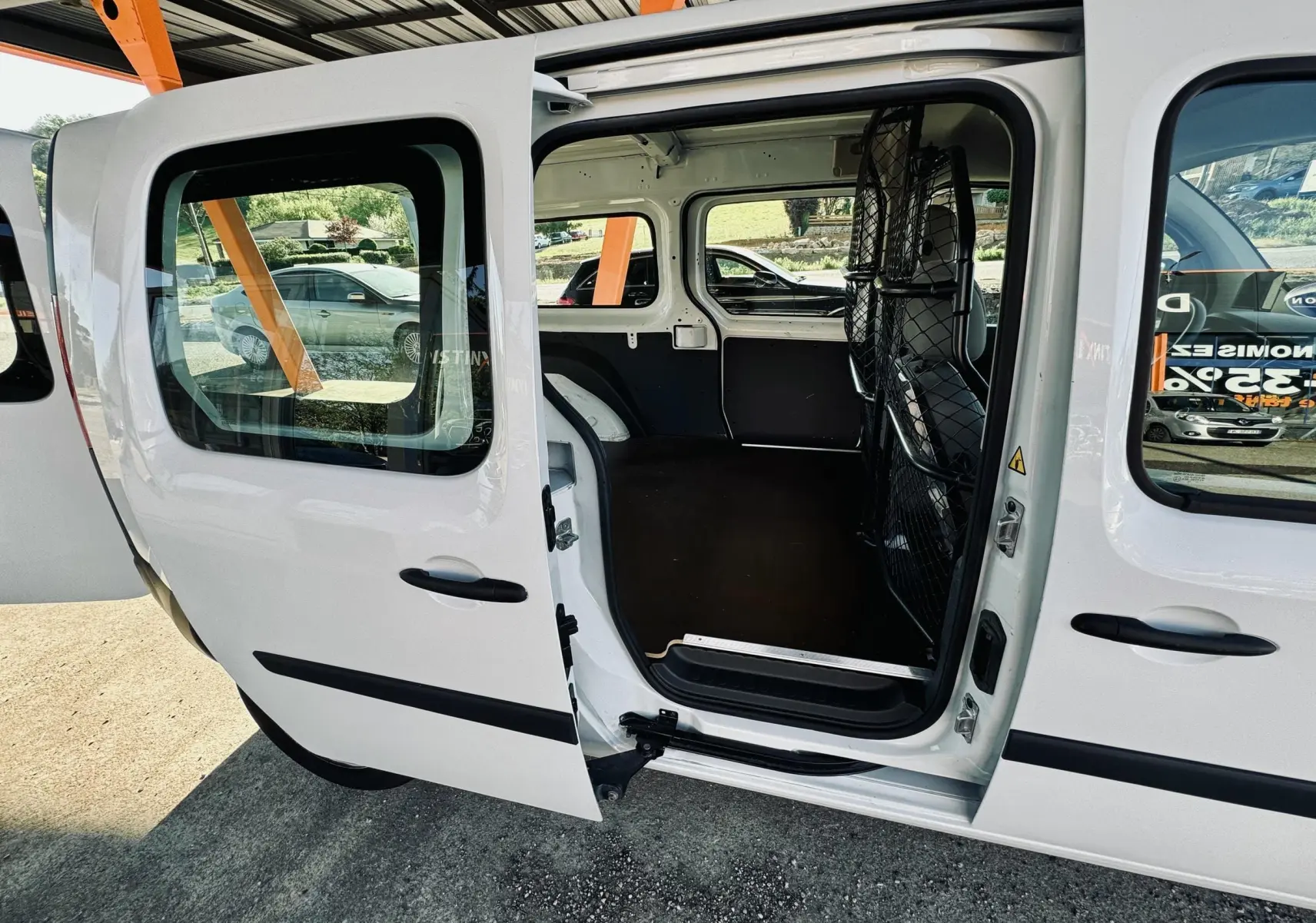 Vue côté gauche du Renault Kangoo Maxi blanc 2021 avec porte coulissante ouverte sur l’espace de chargement vide.