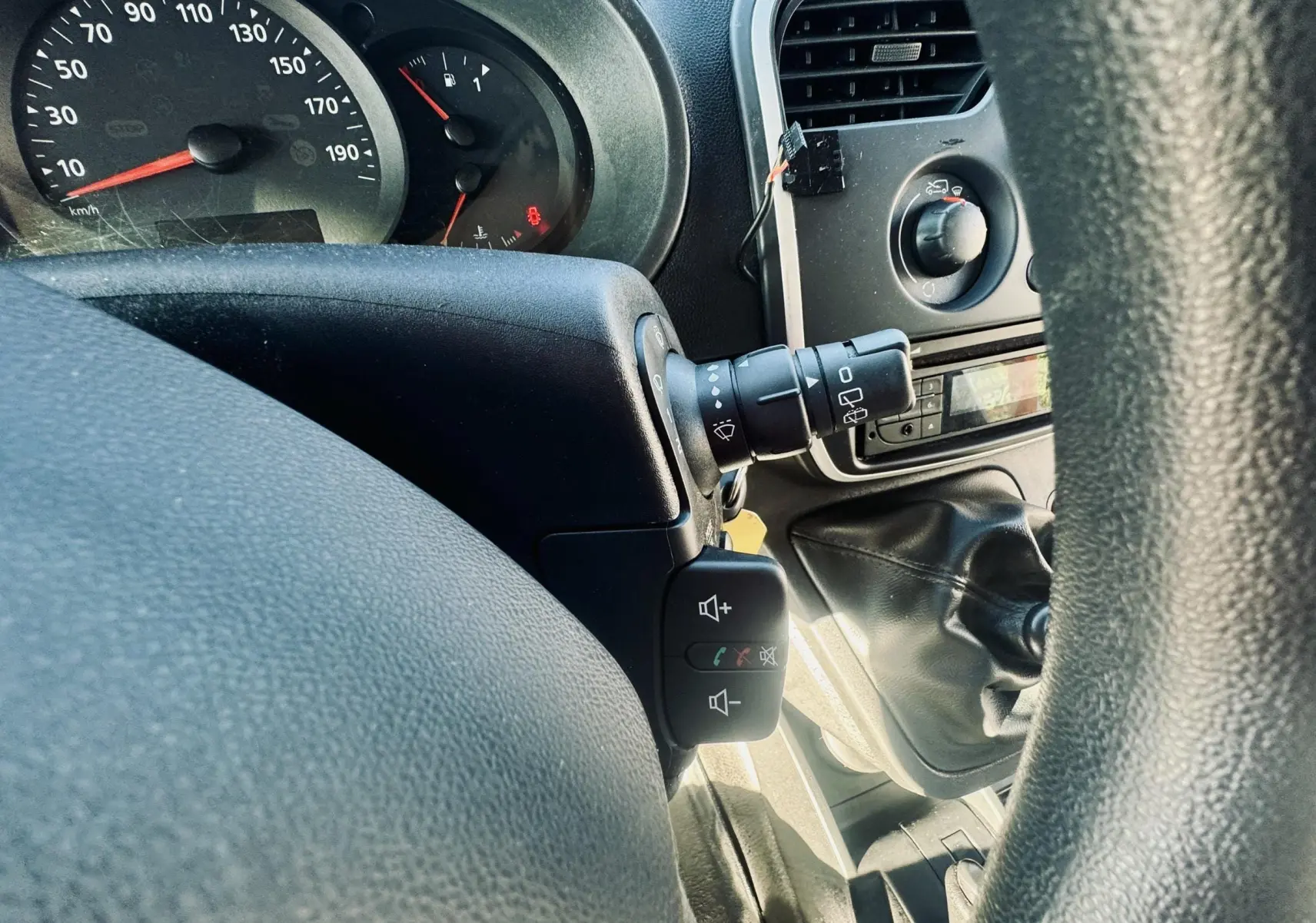 Vue rapprochée du tableau de bord et levier de vitesses d’un Renault Kangoo 2021, intérieur noir.