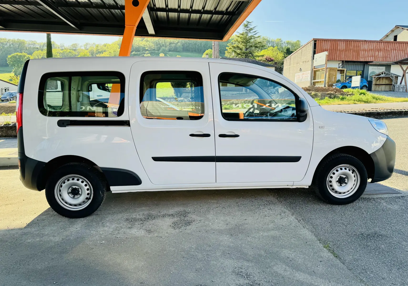 Profil côté gauche d’un Renault Kangoo Maxi blanc de 2021 avec portes coulissantes et jantes acier noires.