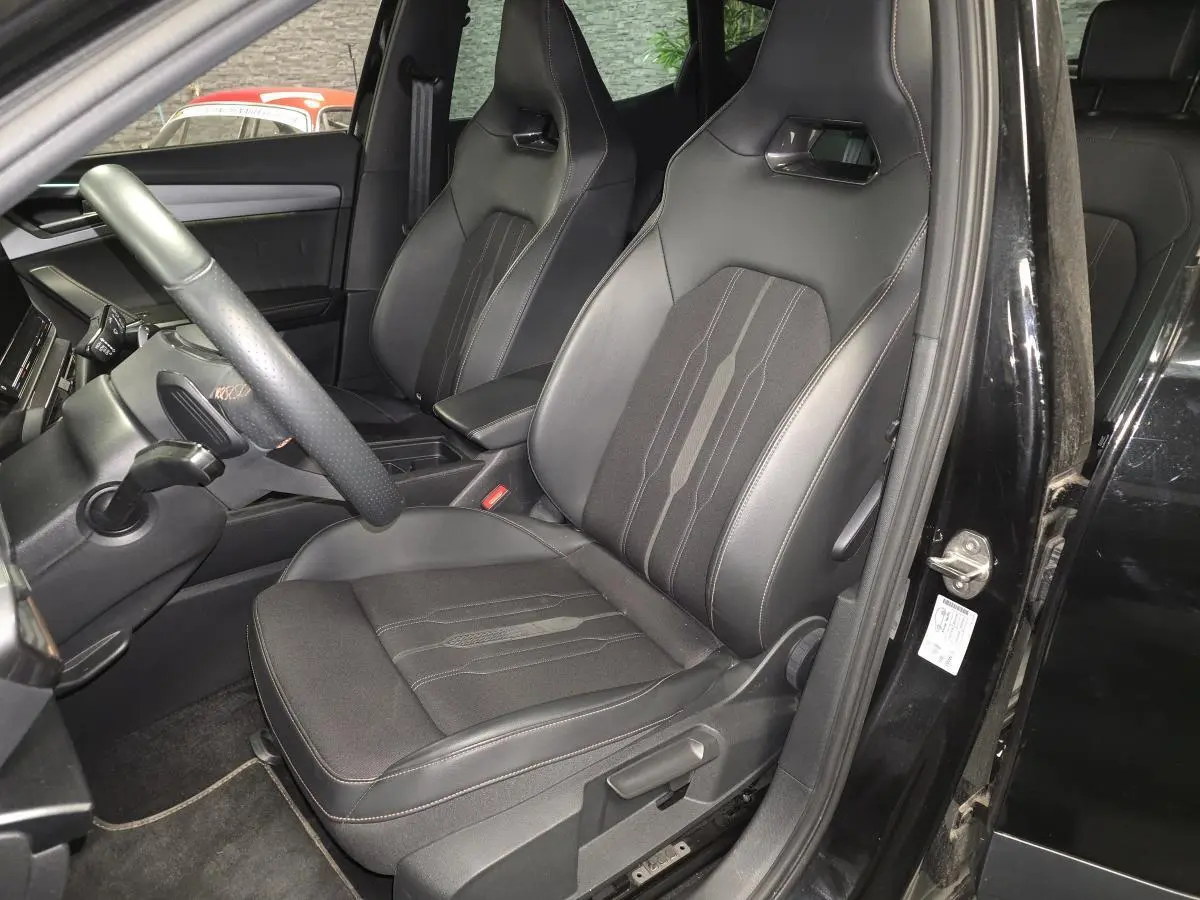 Intérieur côté conducteur du CUPRA Formentor noir, sièges baquets en textile avec surpiqûres cuivre visibles.