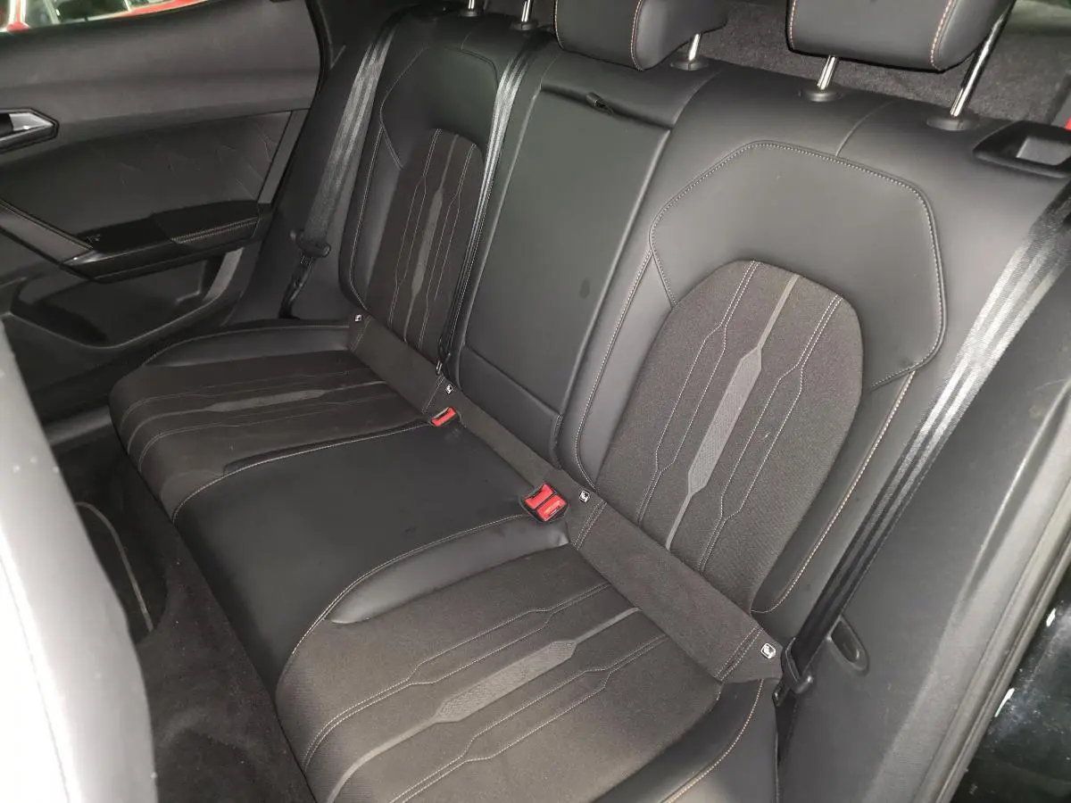 Vue intérieure côté arrière droit des sièges baquets noirs en textile du CUPRA Formentor 1.4 e-Hybrid 2023 avec surpiqûres cuivre.