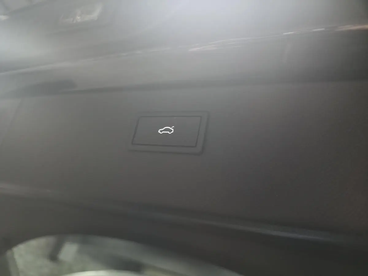 Bouton d'ouverture électrique du hayon sur la partie intérieure noire du coffre d'un CUPRA Formentor noir.