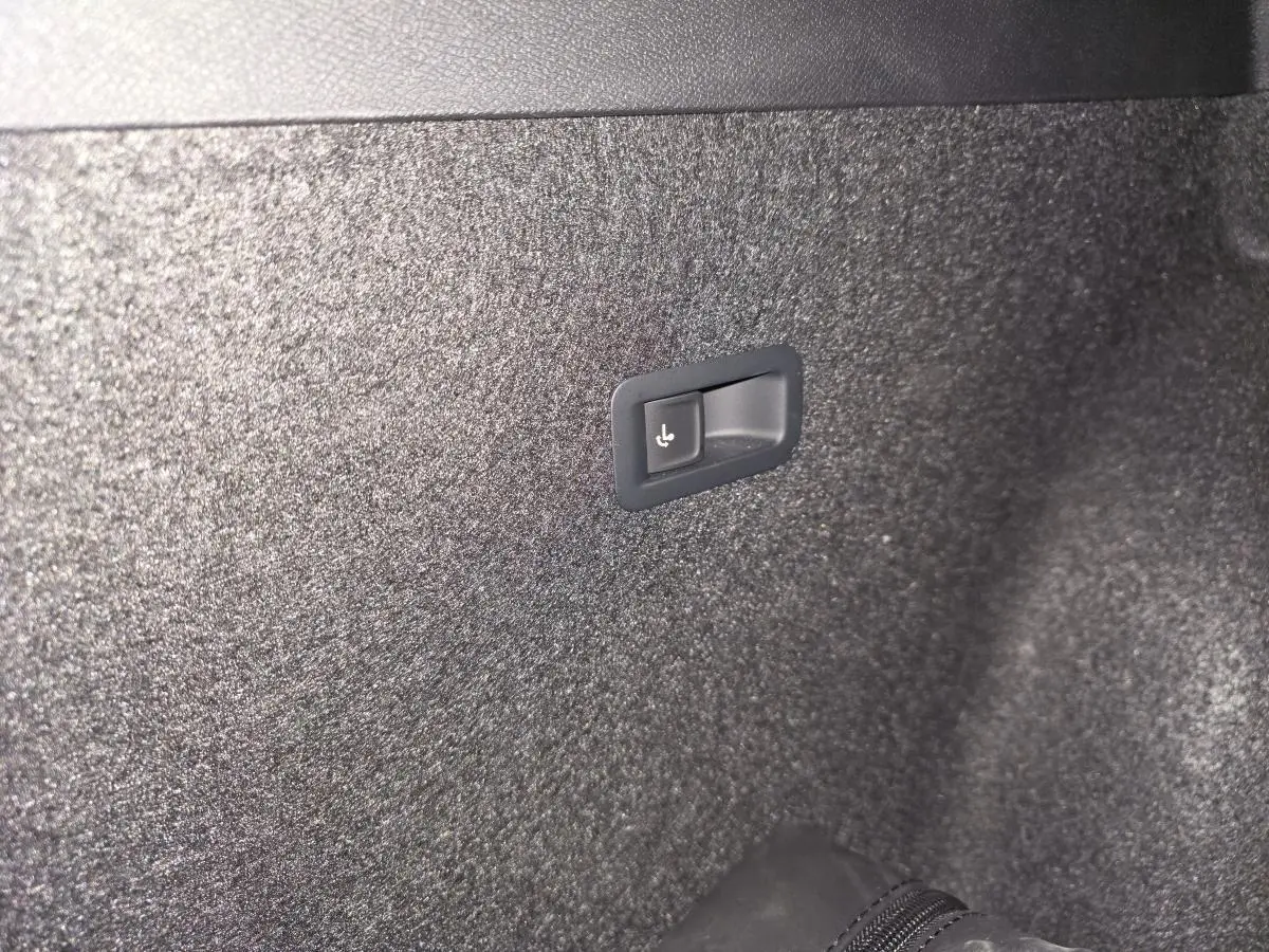 Détail du bouton de rabattement électrique des sièges arrière dans le coffre du CUPRA Formentor noir 2023.