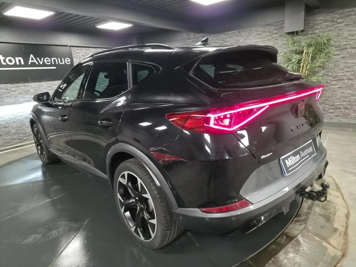 Vue 3/4 arrière droite du CUPRA Formentor noir avec feux arrière LED en bandeau et crochet d'attelage escamotable.