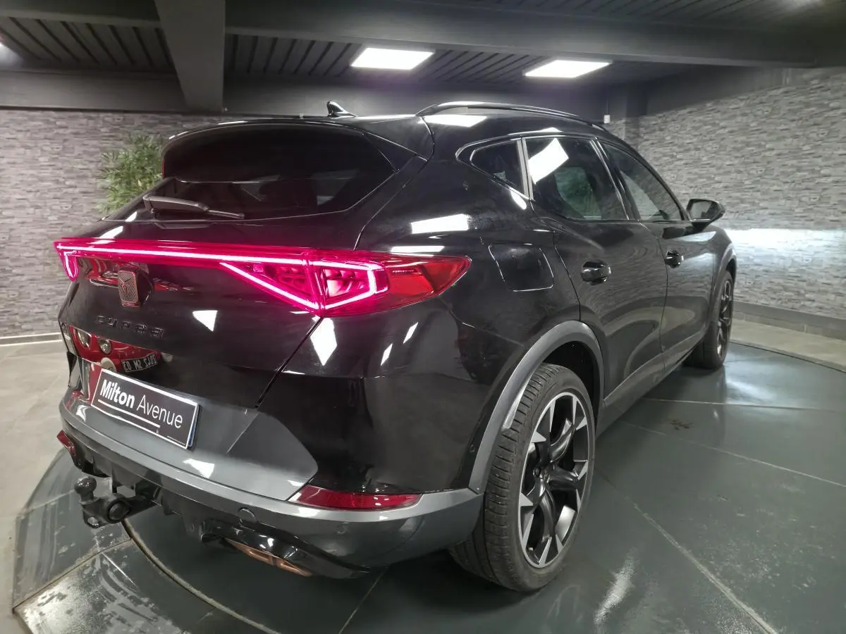 Vue 3/4 arrière droite du CUPRA Formentor noir avec feux arrière LED en bandeau et crochet d'attelage escamotable.
