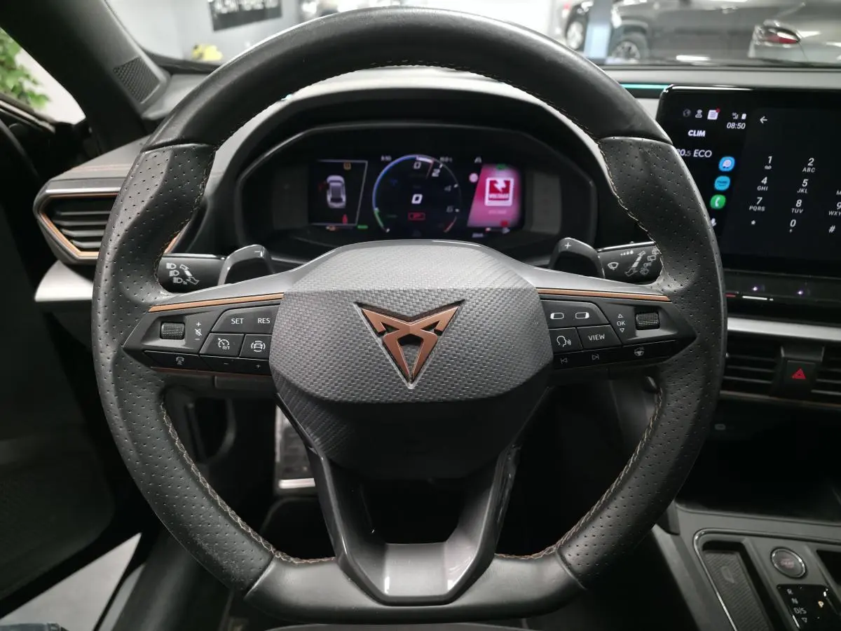 Vue rapprochée du volant sport en cuir noir avec logo Cupra cuivre et tableau de bord digital du Formentor 1.4 e-Hybrid 2023.