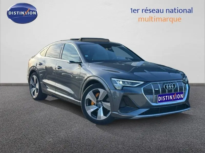 Audi E-Tron Sportback gris foncé métal, vue 3/4 avant droit, avec calandre distinctive et jantes alu spécifiques S Line.