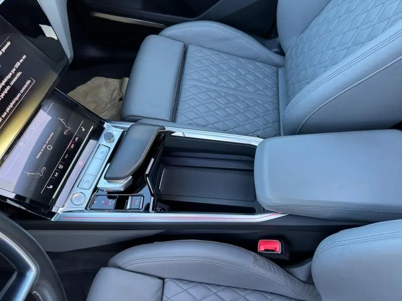 Vue intérieure rapprochée de la console centrale et des sièges gris clair matelassés de l'Audi E-Tron Sportback 50 S Line.