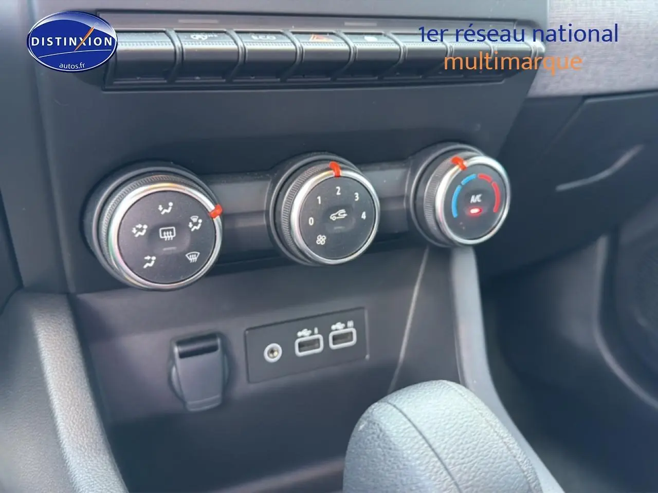 Gros plan sur les commandes de climatisation et les ports USB du tableau de bord de la Renault Clio V gris 2025.