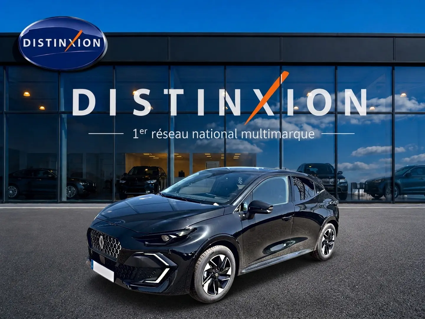 Renault Clio VI noire vue en 3/4 avant droit, avec jantes alliage et calandre distinctive devant showroom Distinxion.