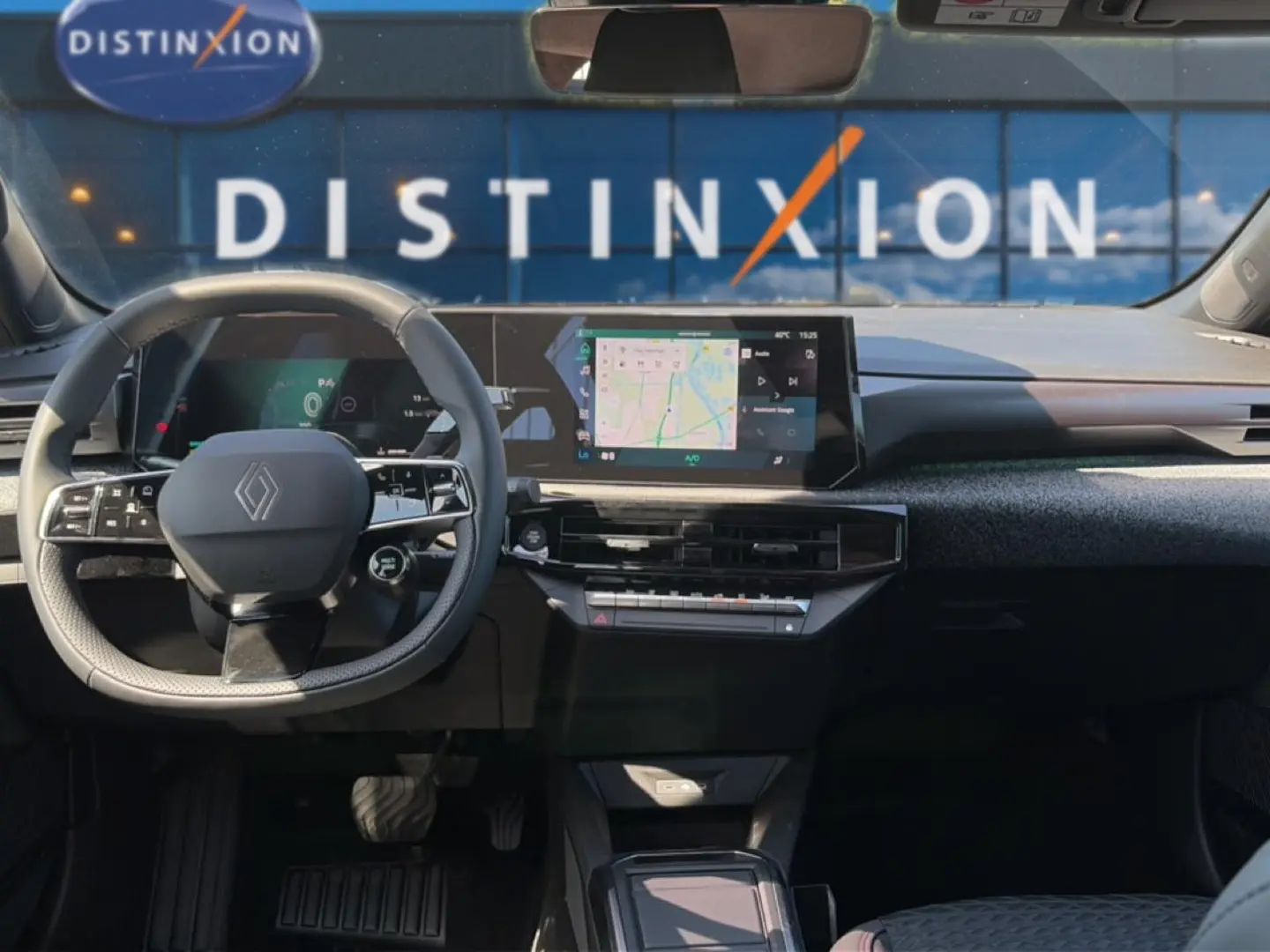 Vue intérieure avant de la Renault Clio VI noire, avec volant multifonctions et écran tactile central affichant la navigation.