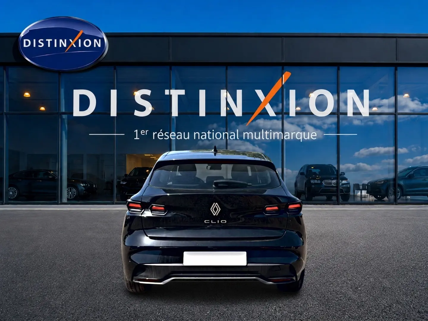 Vue arrière d'une Renault Clio VI noire 2026, avec feux LED et logo distinctif, devant une vitrine Distinxion.