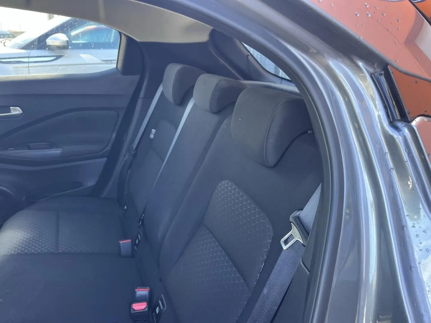 Vue intérieure côté droit sur la banquette arrière en tissu noir du Nissan Juke gris Argile Spéciale 2023.