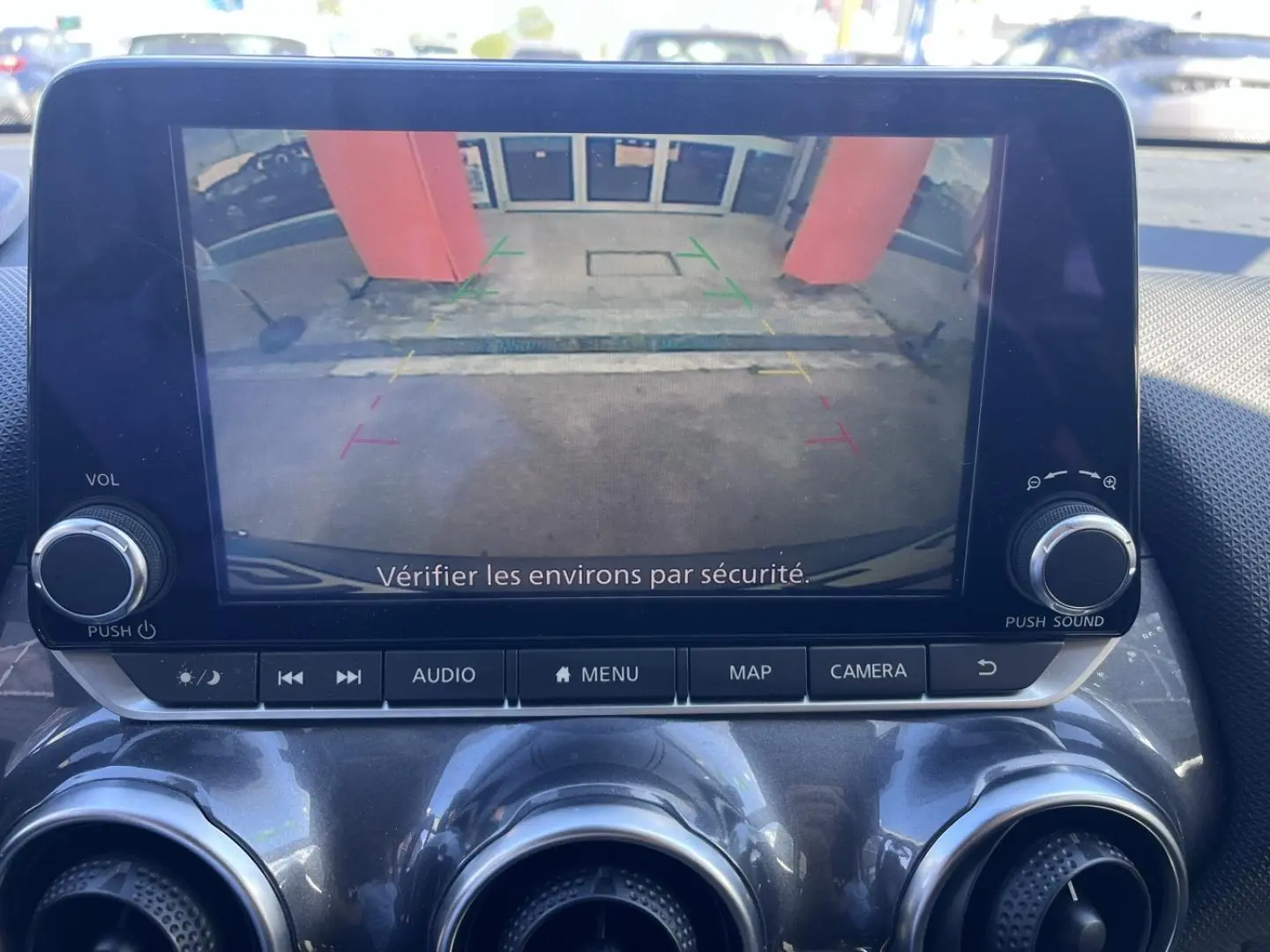 Écran tactile intérieur du Nissan Juke 2023 montrant la caméra de recul avec vue arrière et guidage coloré.