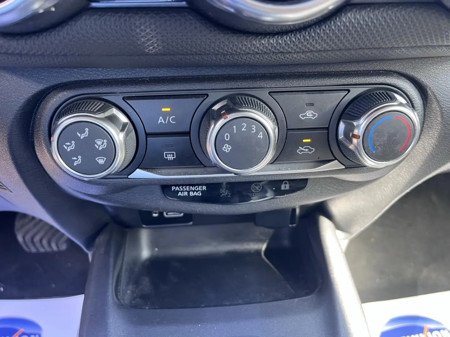 Gros plan sur les commandes de climatisation manuelle du Nissan Juke 2023, avec boutons rotatifs noirs et argentés.