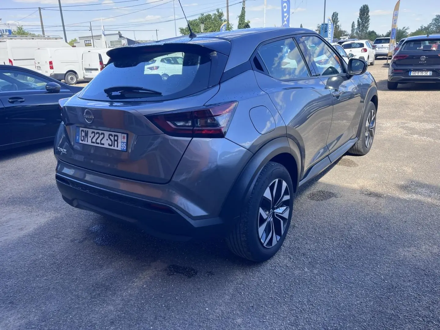 Vue 3/4 arrière droite d'un Nissan Juke 2023 gris argile avec jantes bi-ton et feux arrière LED.