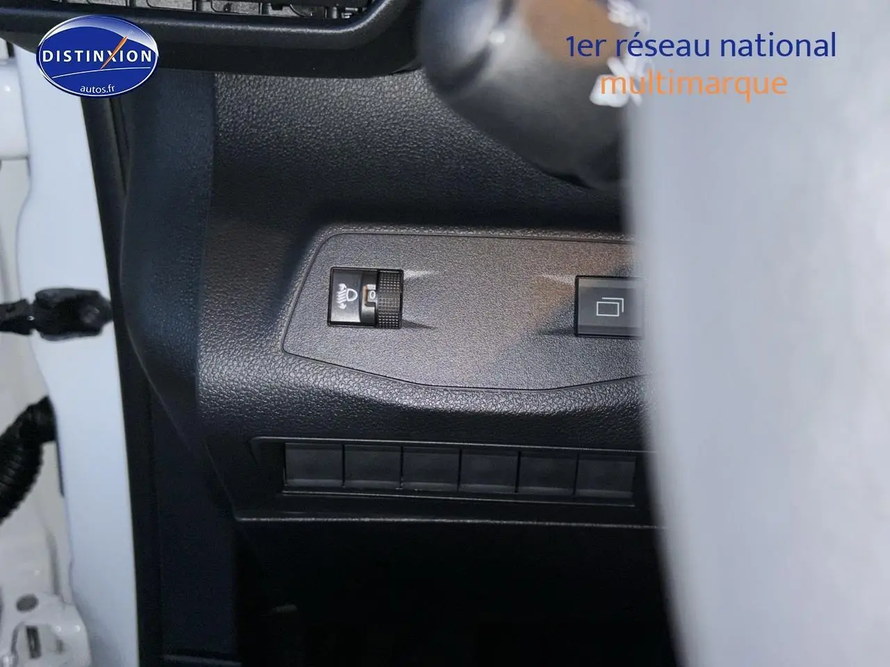 Détail du tableau de bord côté gauche du Citroën Berlingo Fourgon blanc, avec commandes d'éclairage et bouton carré.