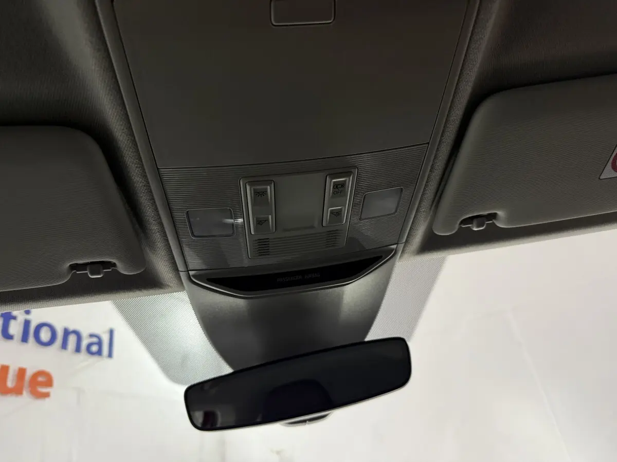 Vue intérieure centrée sur le plafonnier et le rétroviseur intérieur d'une Skoda Kamiq rouge 2024.