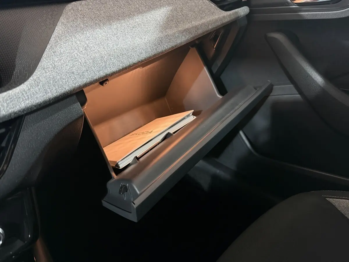 Gant de boîte à gants ouvert côté passager dans l’habitacle sombre d’une Skoda Kamiq 2024.