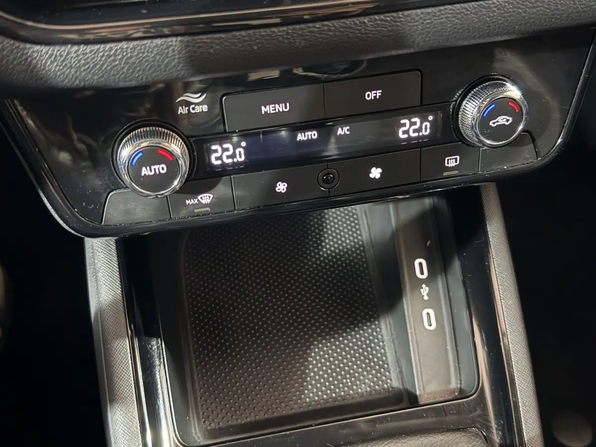 Vue rapprochée de la console centrale noire du Skoda Kamiq 2024 avec commandes climatisation digitale à 22°C.