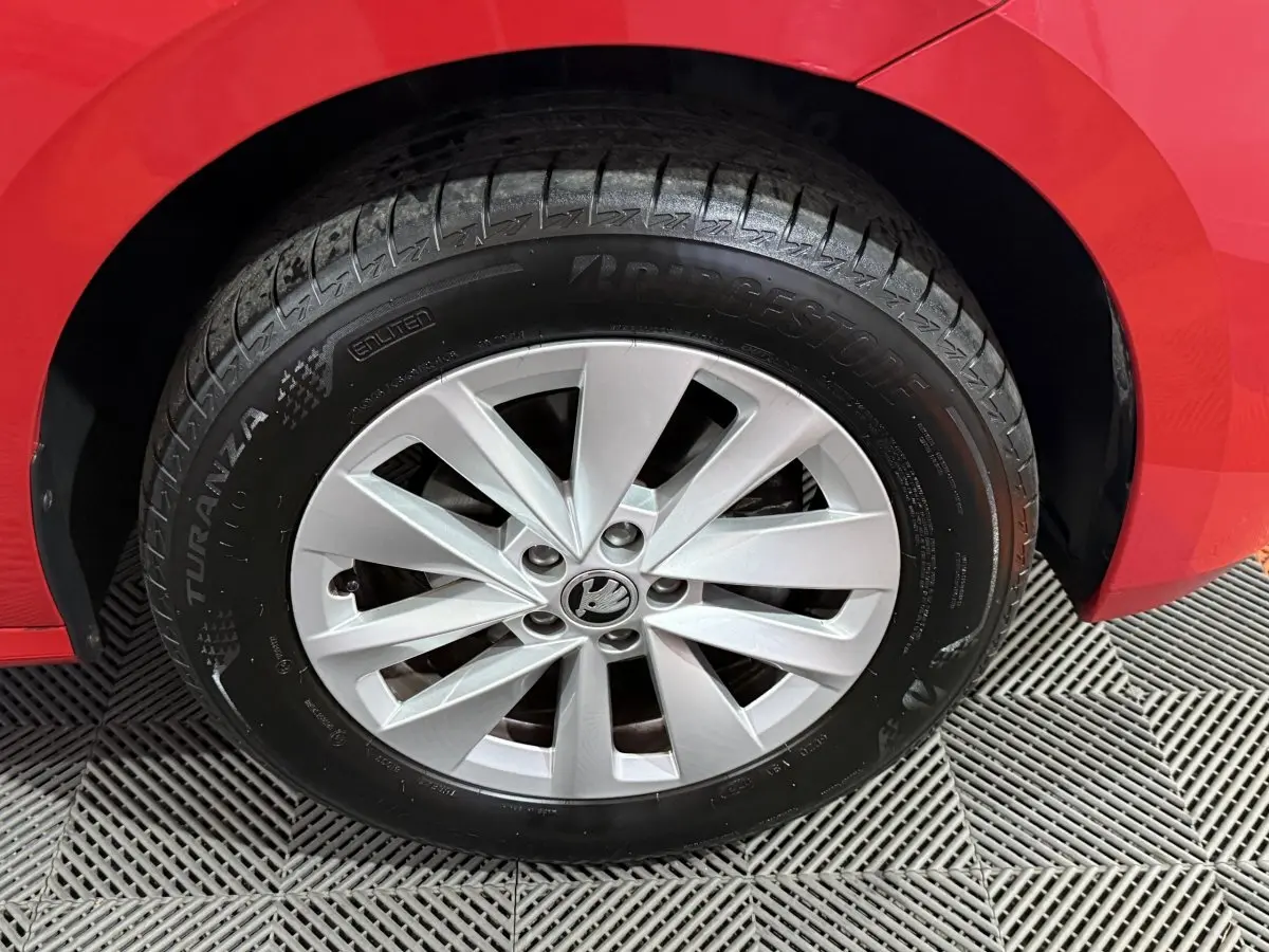 Gros plan sur la roue avant gauche rouge d’un Skoda Kamiq 2024 avec jante argentée et pneu Bridgestone Turanza.