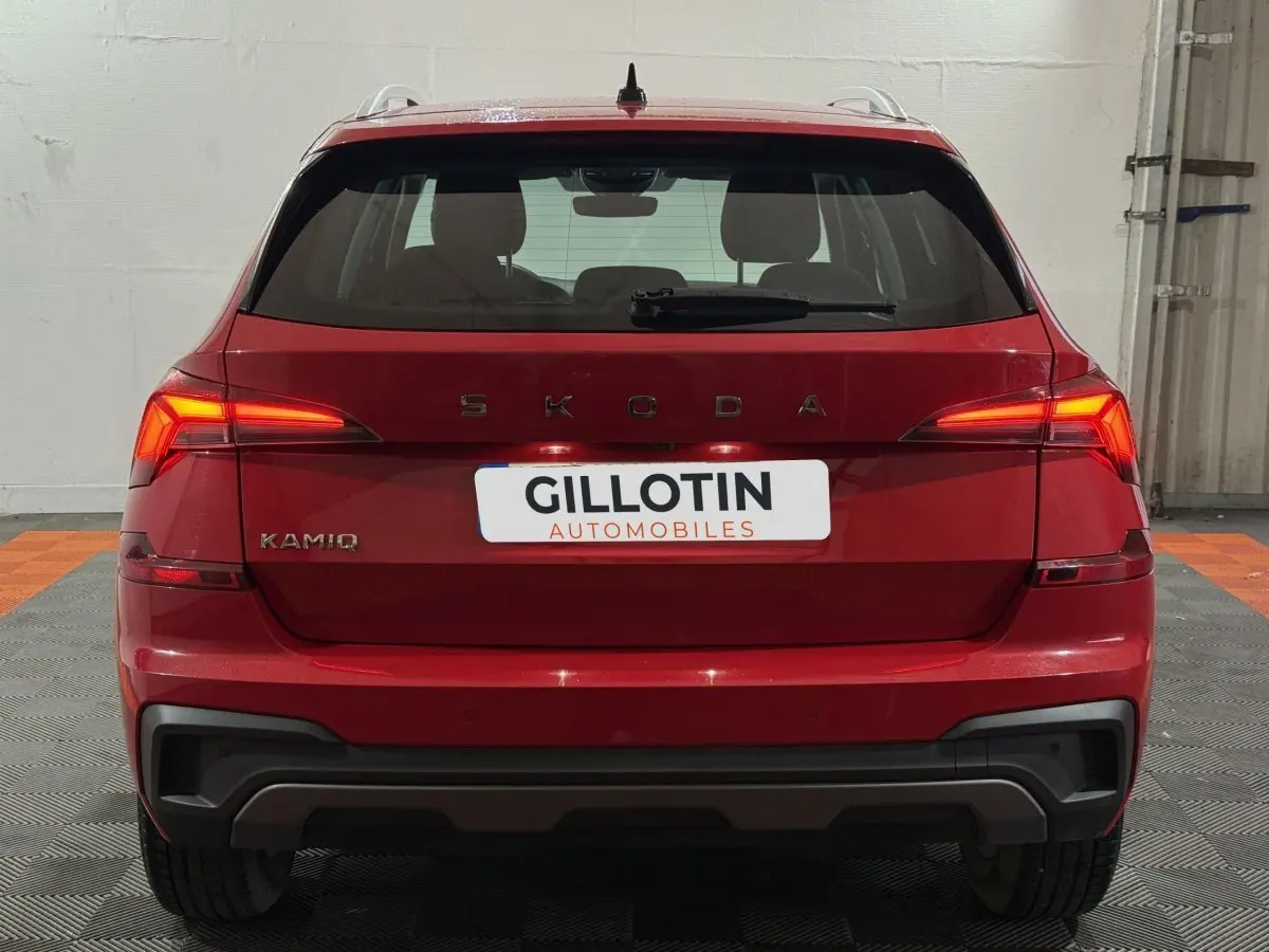 Vue arrière d'un Skoda Kamiq rouge 2024 avec feux LED allumés dans un garage.