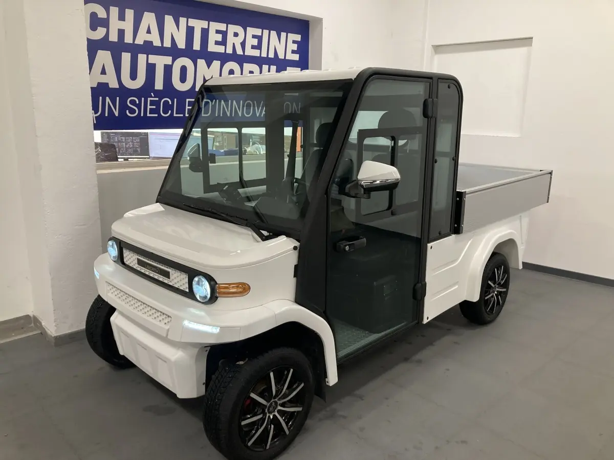 Vue 3/4 avant droite du pick-up électrique blanc Liberty L7E H2 160 avec kit ridelles et jantes alliage 13 pouces.