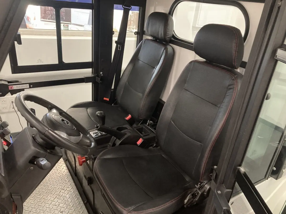 Vue intérieure côté conducteur du Liberty L7E H2 160 blanc, montrant les sièges noirs et le volant 3 branches.