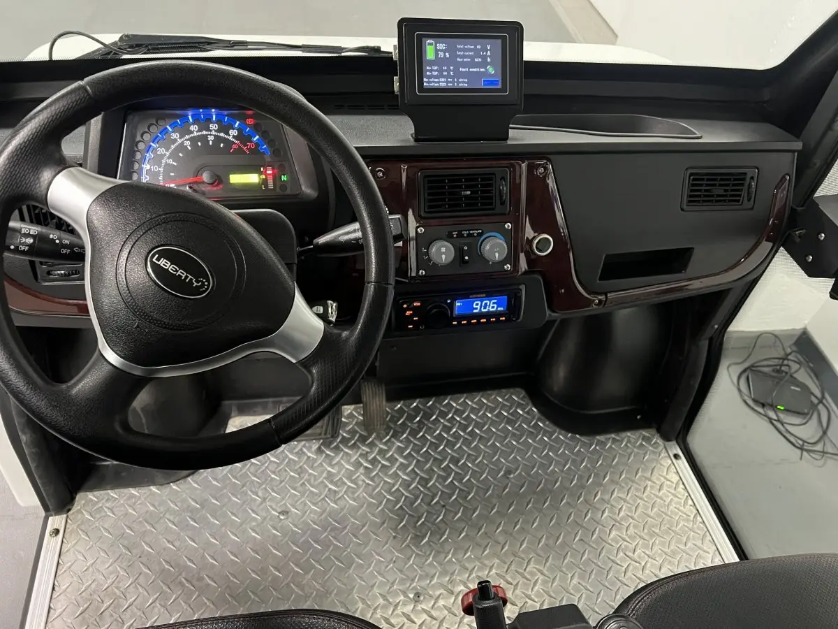 Vue intérieure de face du tableau de bord du Liberty L7E H2 160 blanc, volant 3 branches et revêtement sol aluminium.