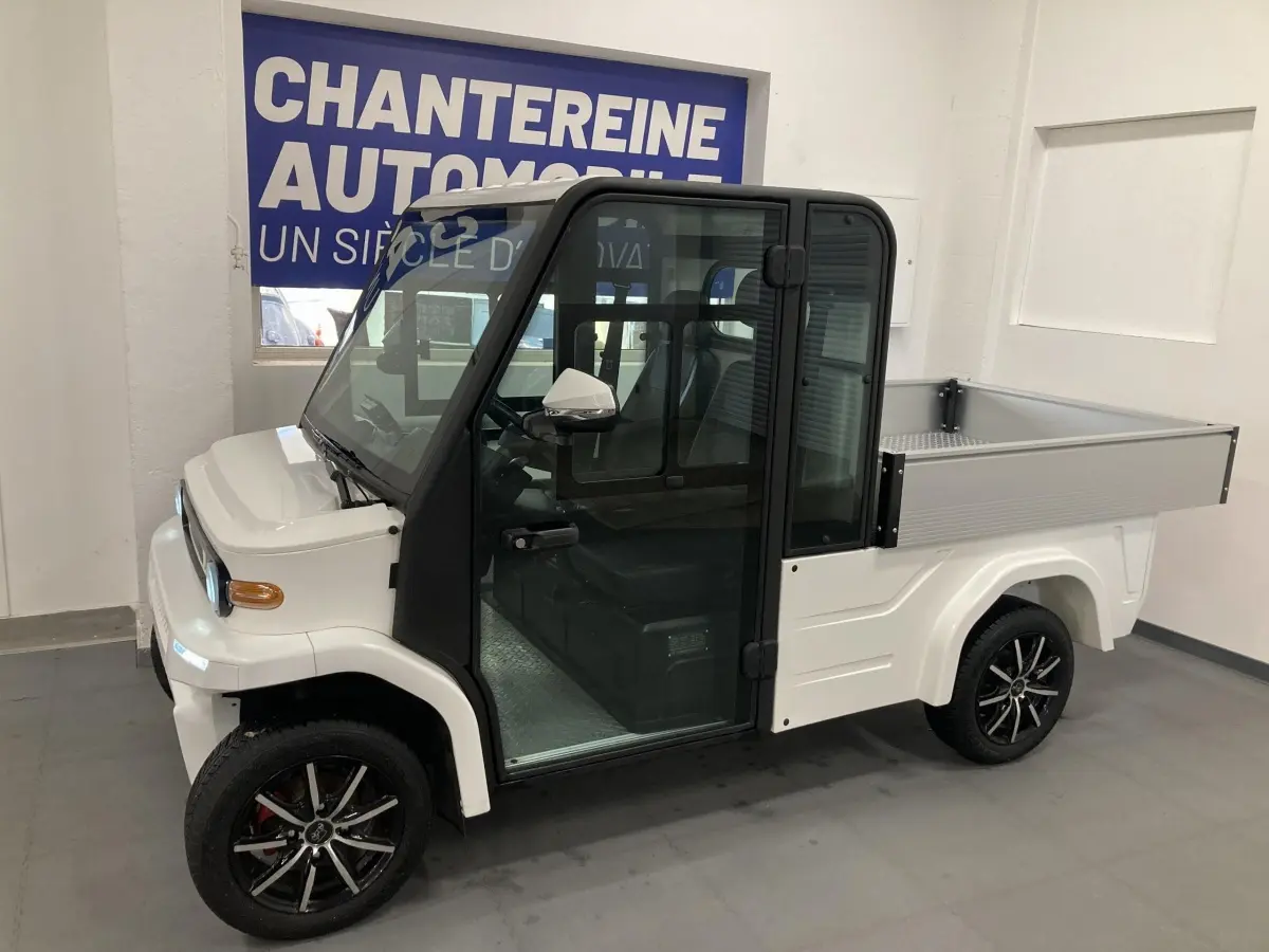 Vue de profil droit d'un utilitaire électrique blanc LIBERTY L7E H2 160 KIT RIDELLES avec jantes alliage noires et cabine vitrée.