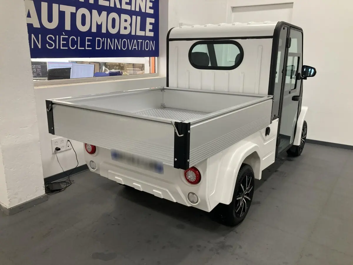Vue 3/4 arrière droite du pick-up électrique blanc Liberty L7E H2 160 avec kit ridelles et jantes alliage noires.
