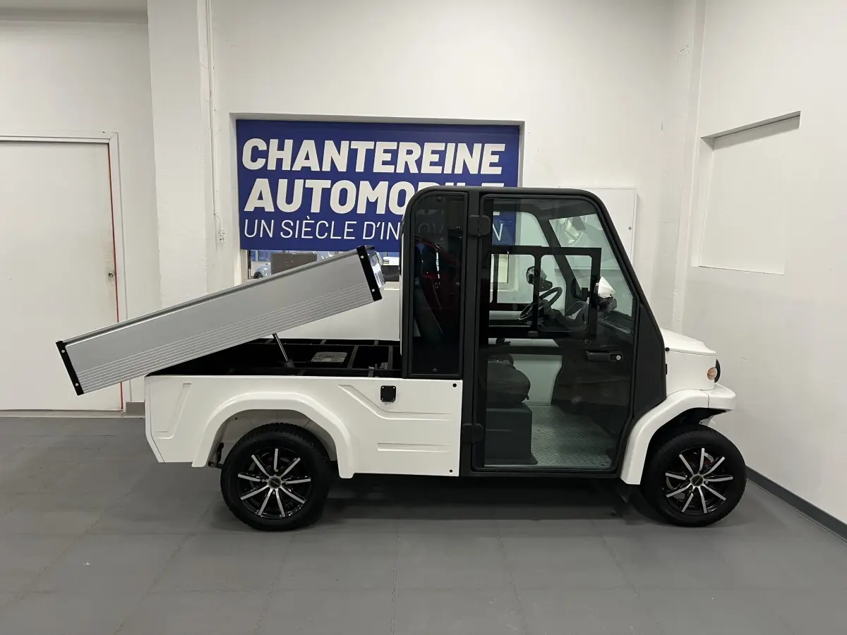 Vue de profil côté gauche du Liberty L7E H2 160 blanc avec kit ridelles relevé et jantes alliage noires 13 pouces.