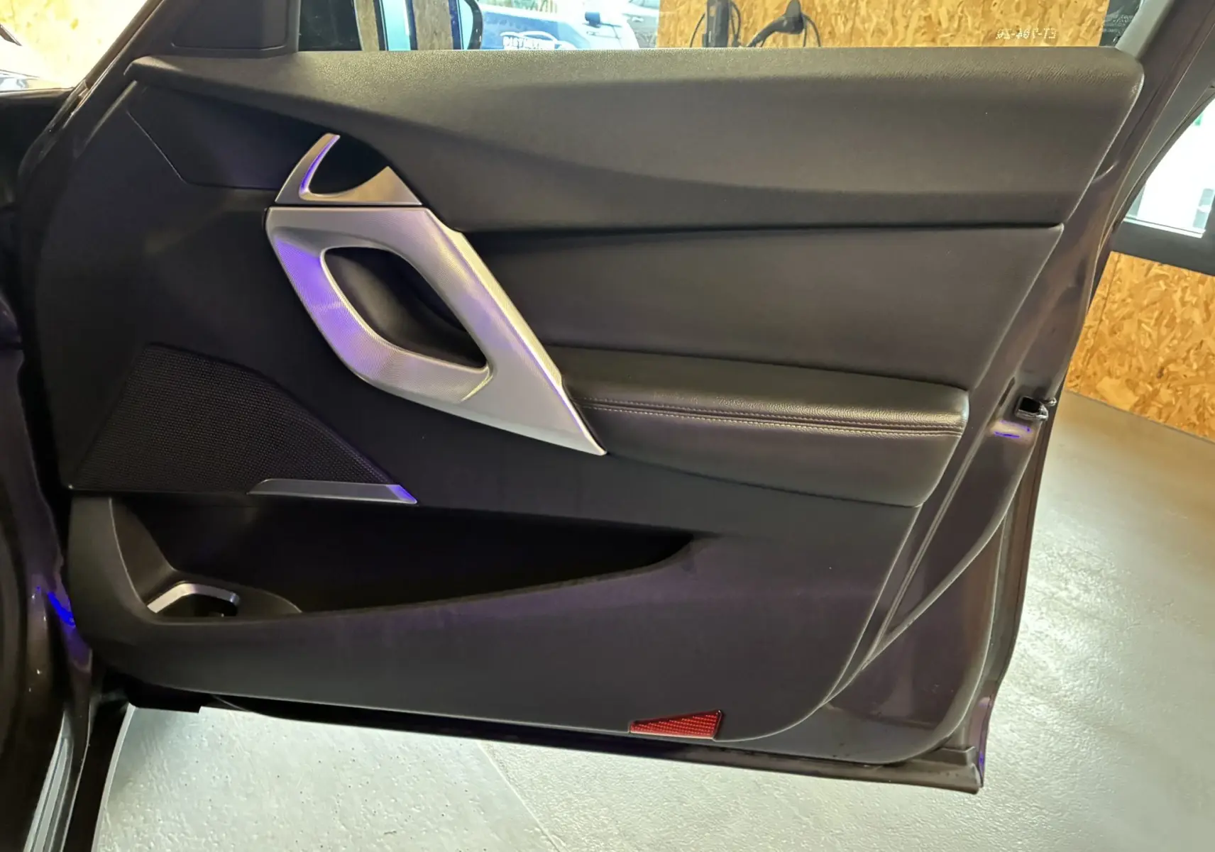 Vue intérieure de la porte avant gauche gris foncé du DS5 2018 avec poignée argentée et garniture noire en cuir.