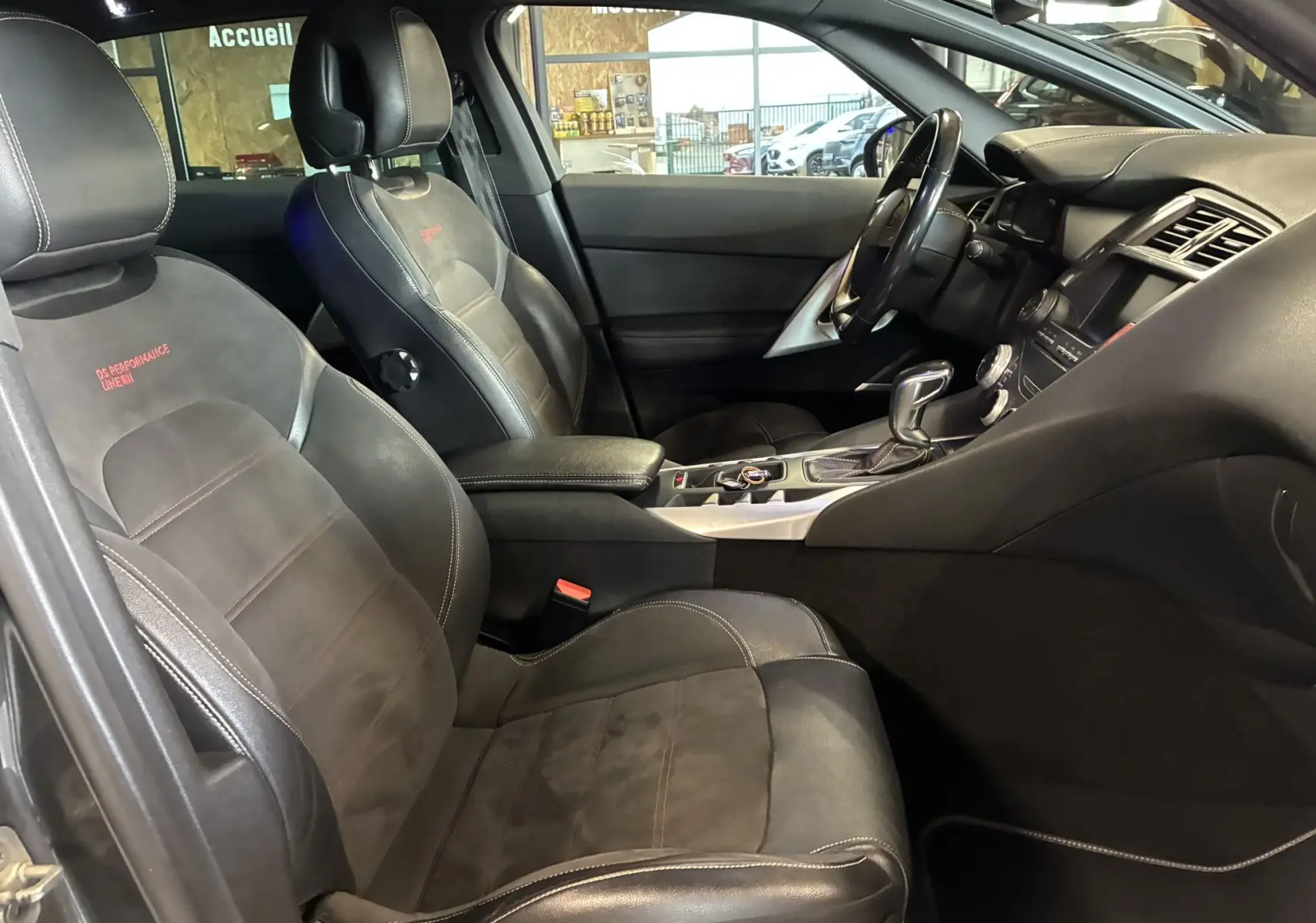 Vue intérieure côté conducteur du DS5 gris 2018, sièges noirs en cuir et alcantara avec logo DS Performance brodé.