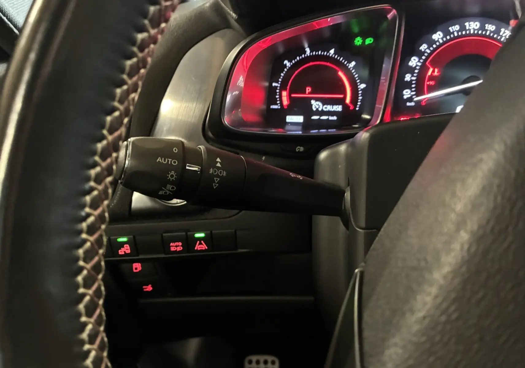 Gros plan sur le tableau de bord et le commodo gauche du DS5 2.0 BlueHDi 180, avec éclairage rouge et commandes visibles.