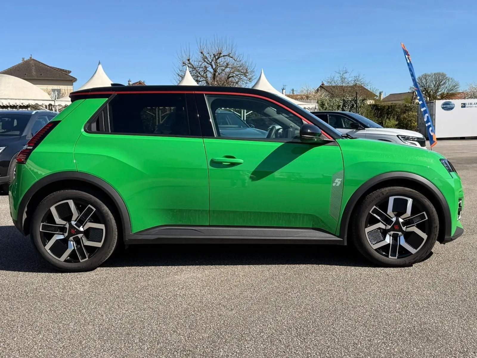 Profil droit d'une Renault R5 E-TECH 100% électrique 2024 en vert Pop avec toit noir étoile et jantes bi-ton.