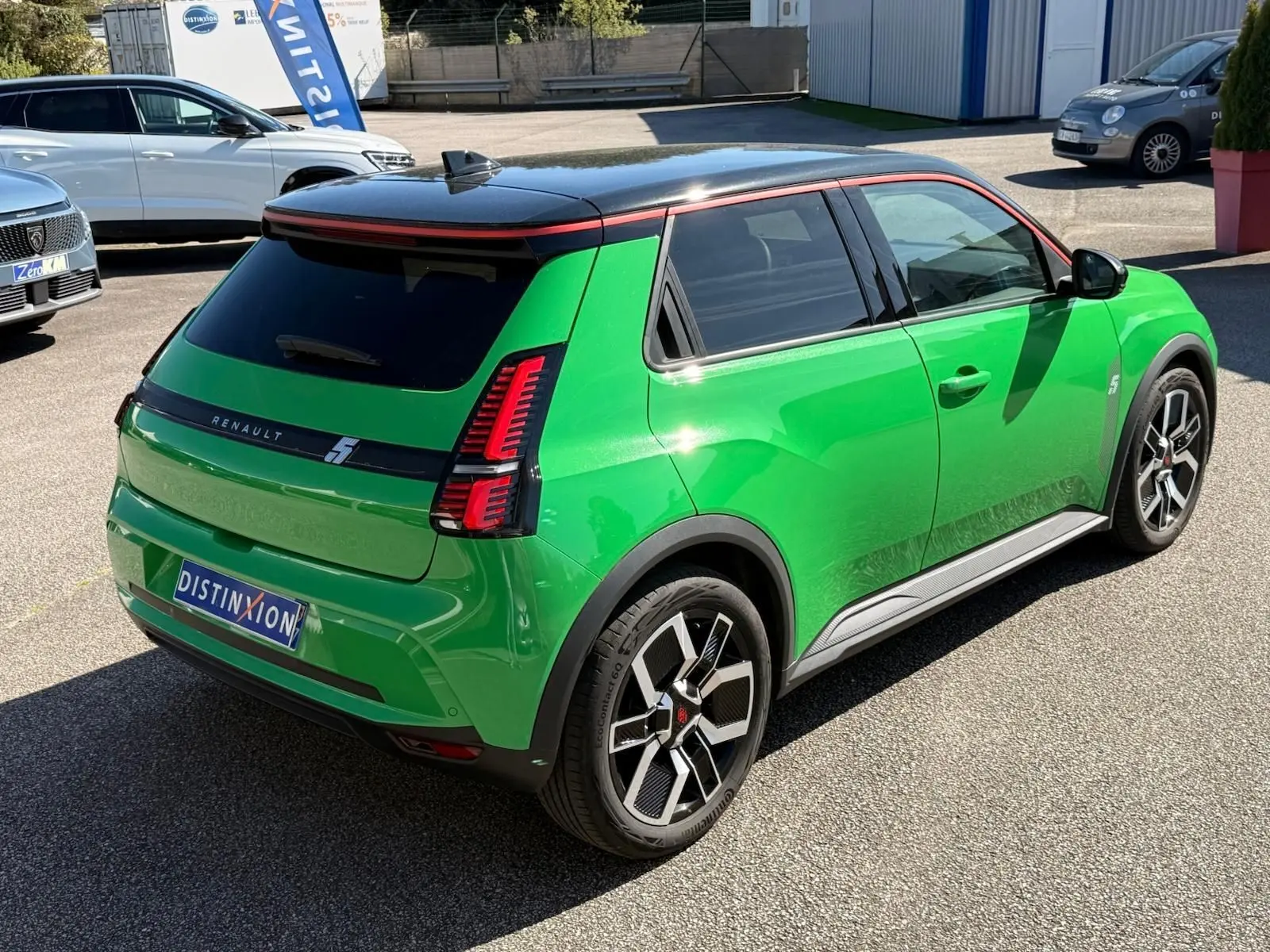 Vue 3/4 arrière droite d’une Renault R5 E-Tech électrique vert Pop avec toit noir étoile et jantes bi-ton.